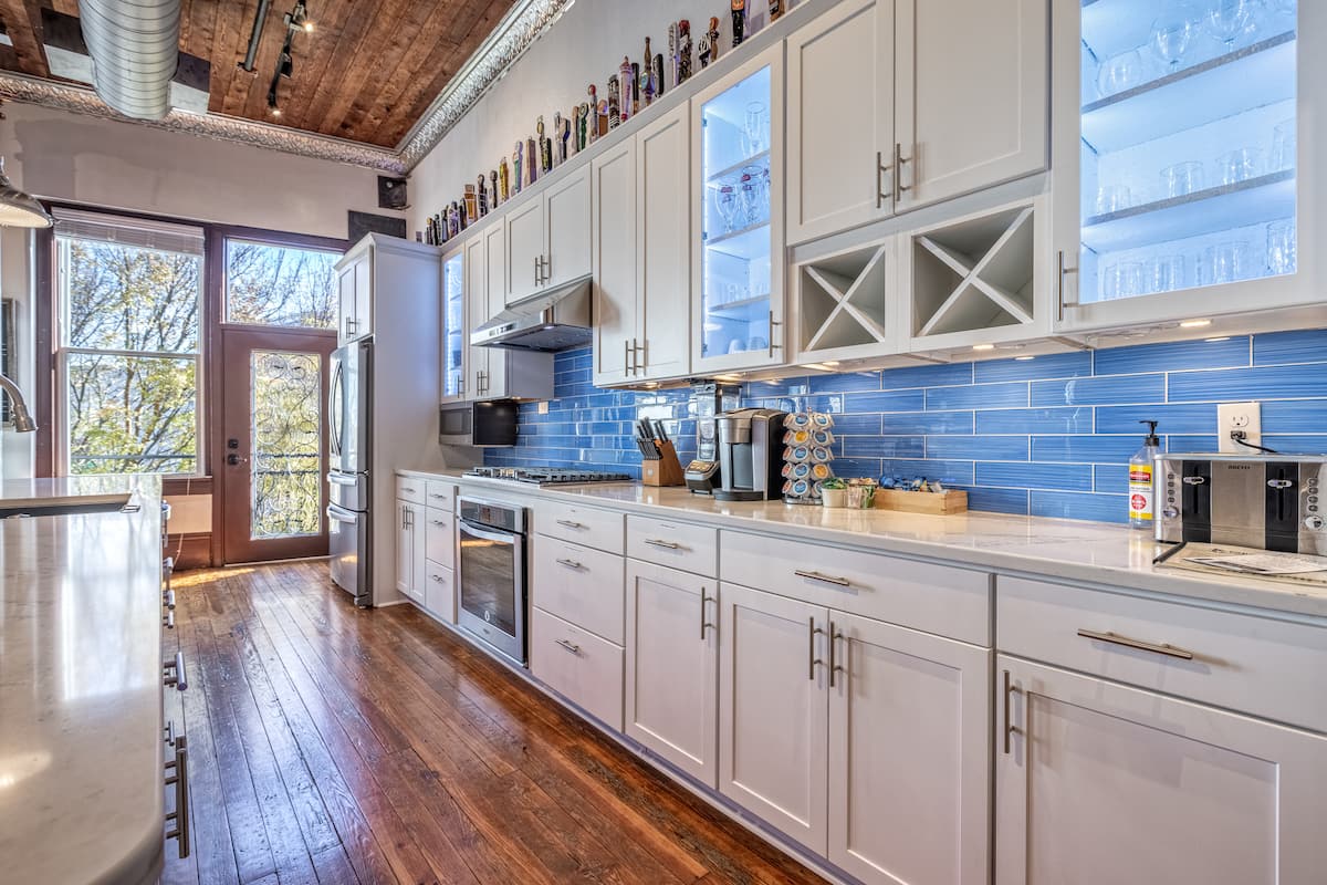 Full kitchen with blue tile backsplash and original wood floors