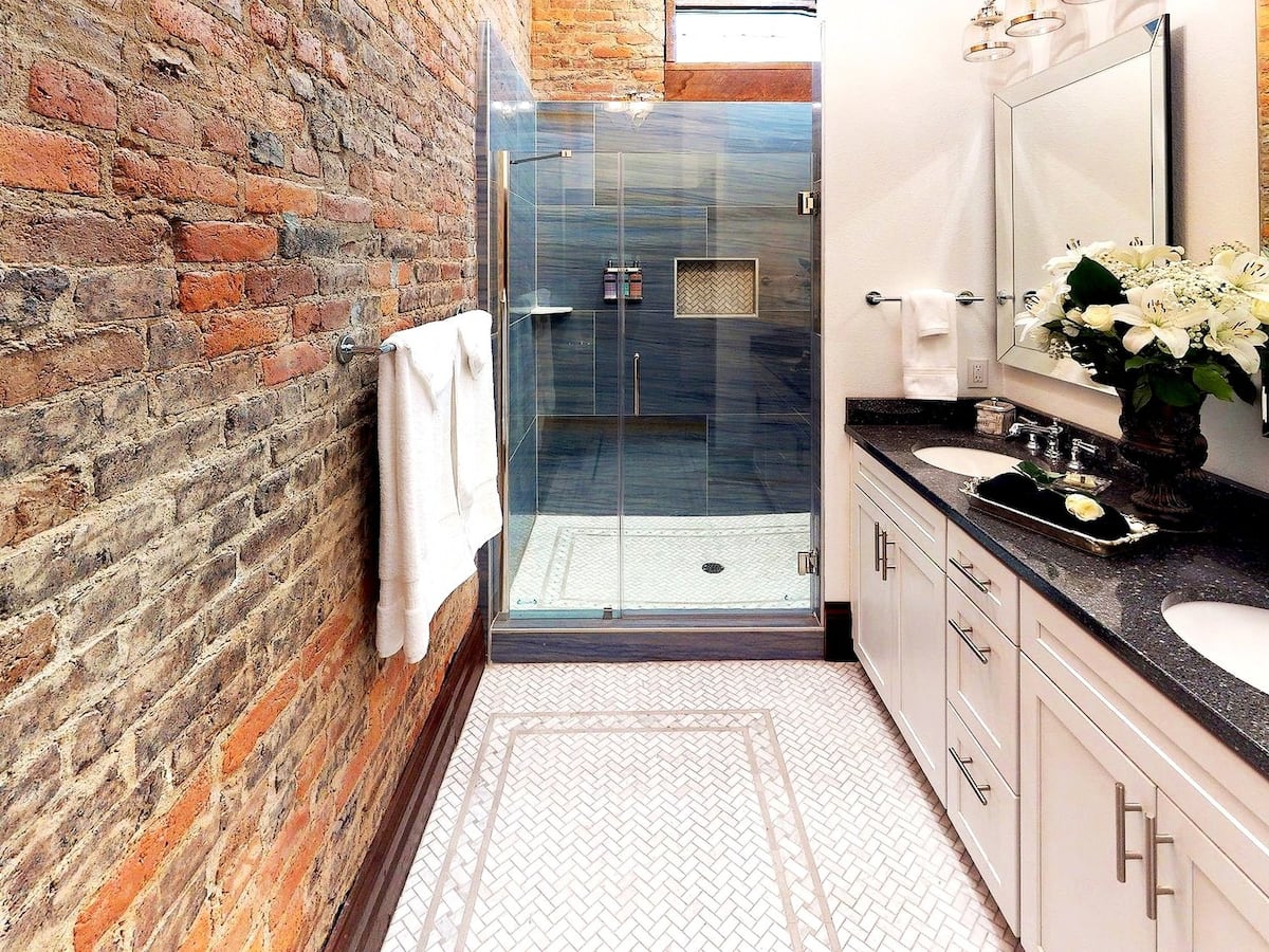 Bathroom with exposed brick and walk-in glass shower
