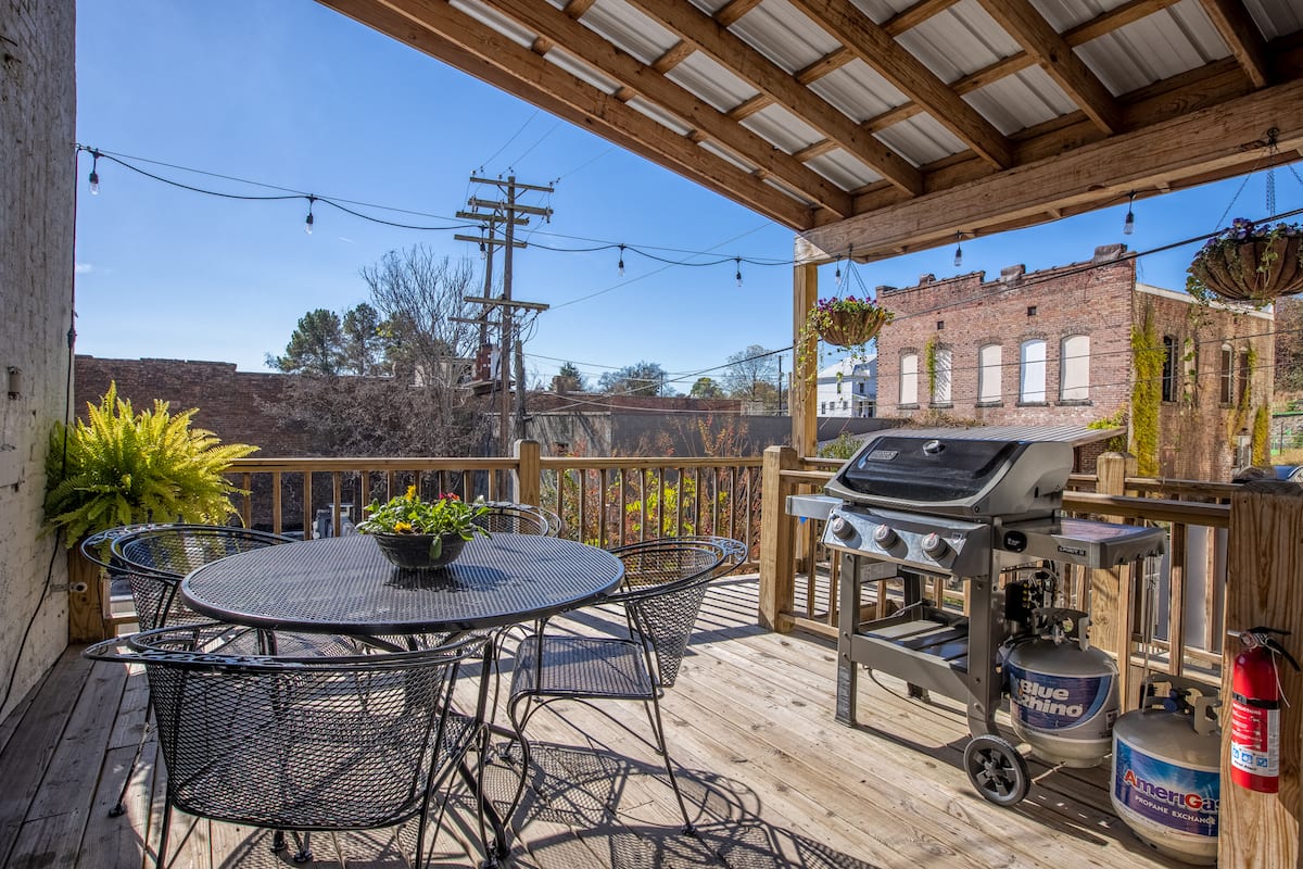 Covered rear patio with dining table and grill
